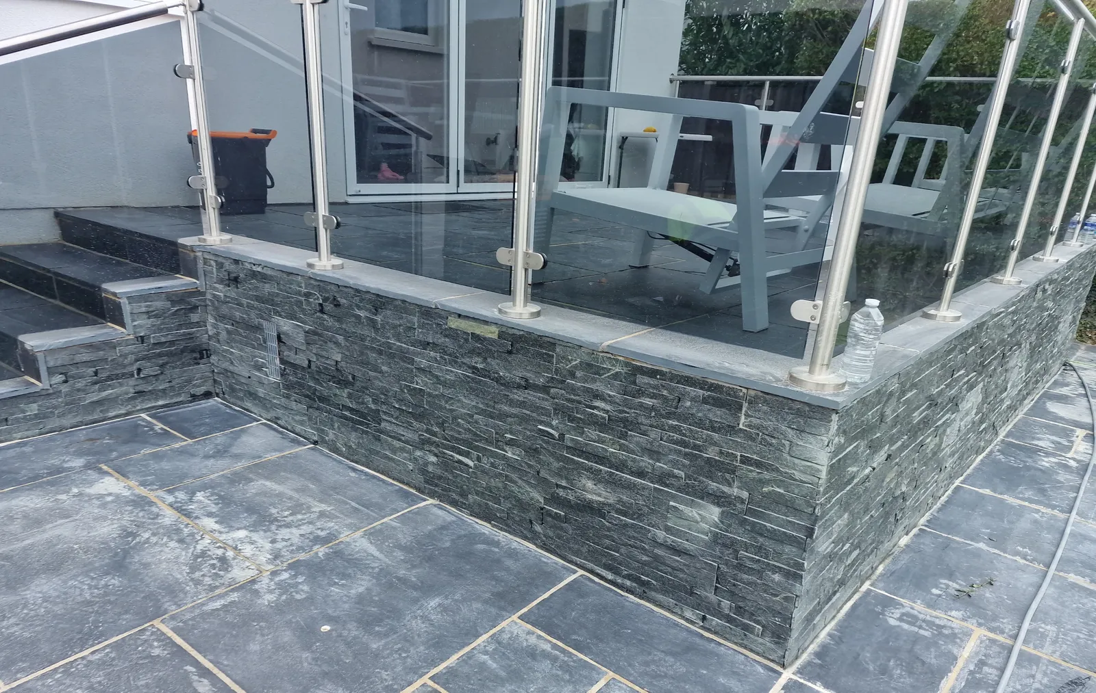 Slate-clad garden wall with glass balustrade
