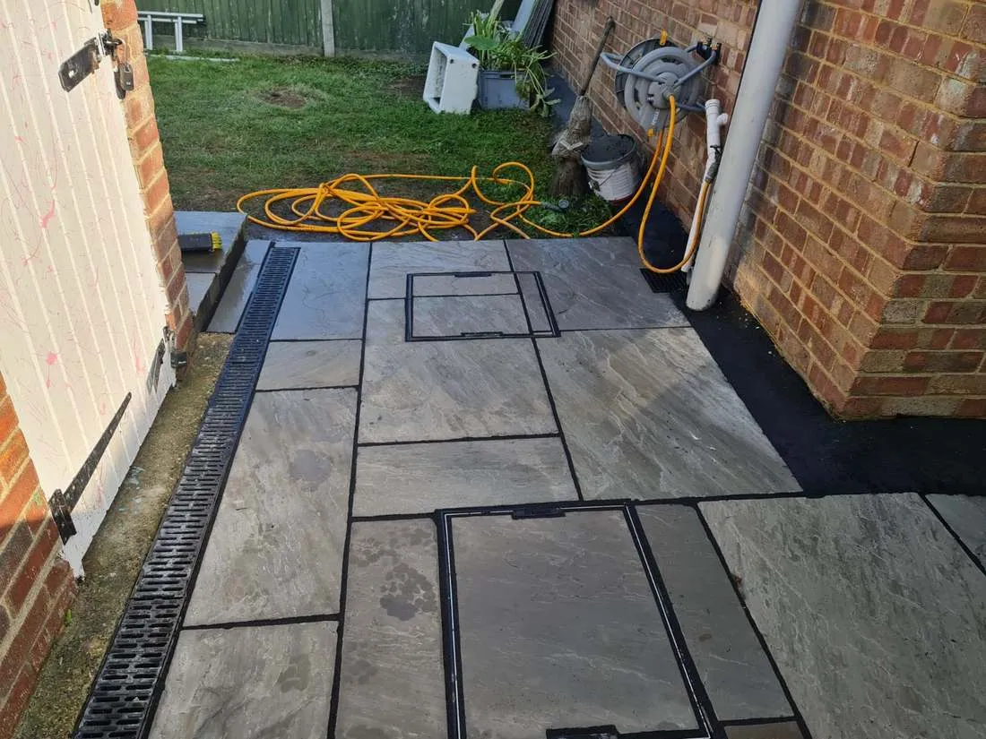 Sandstone patio with linear drain channel and inspection cover by DJG Groundworks