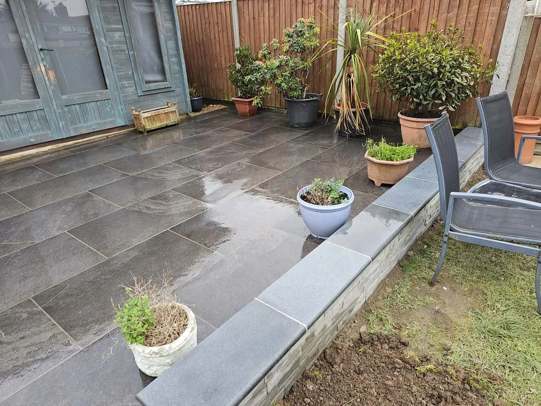Porcelain patio with granite coping and planters by DJG Groundworks