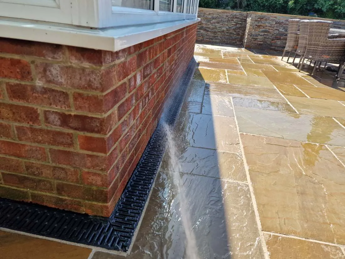 Sandstone patio with brick edge and drainage channel by DJG Groundworks