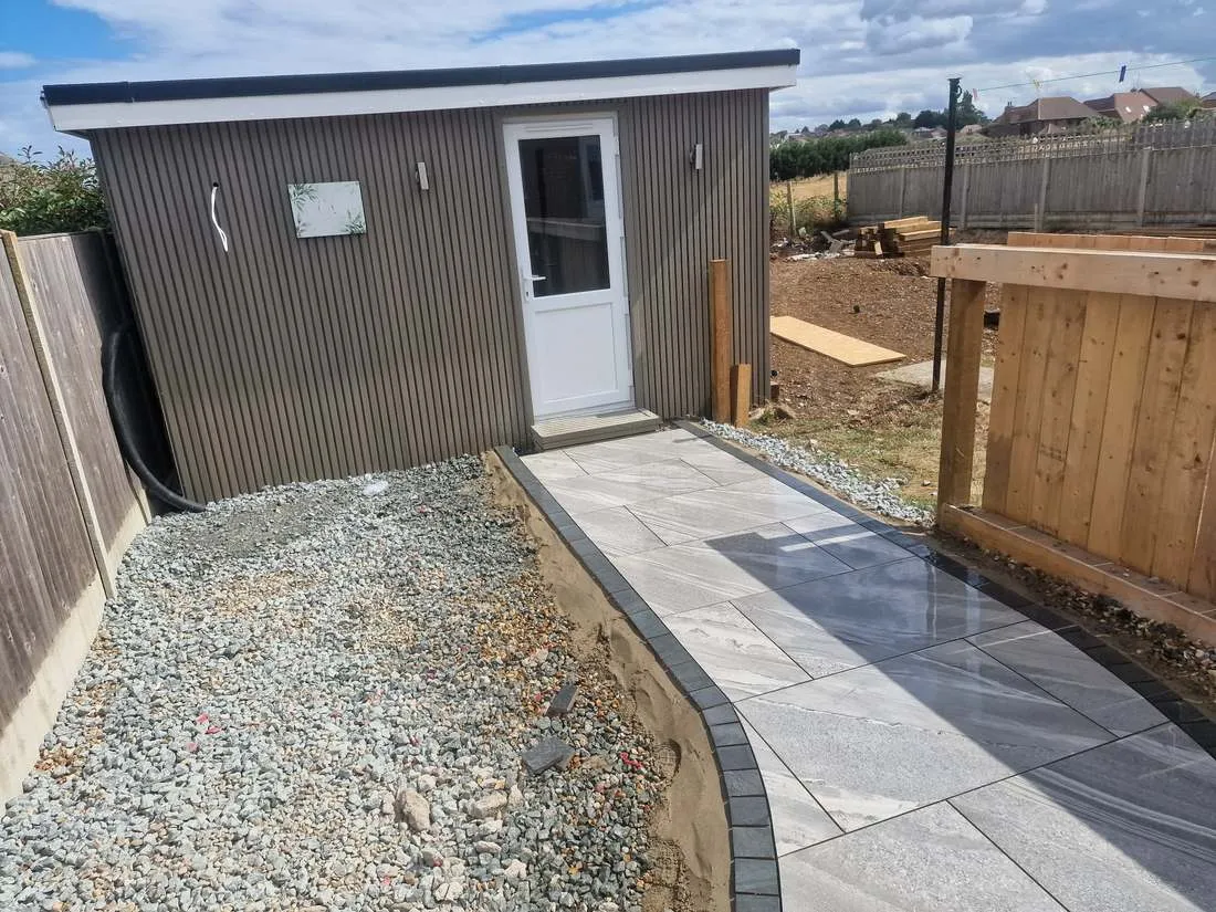 Porcelain path curving round to a garden building by DJG Groundworks