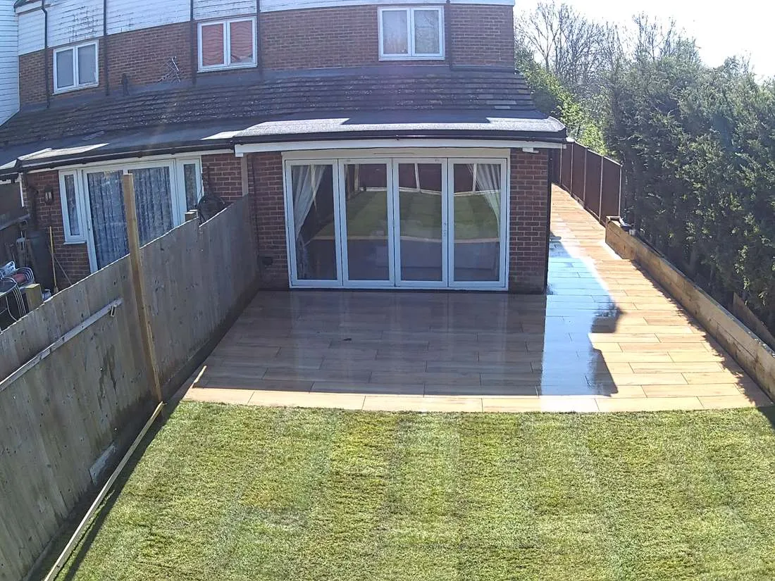 Wood-effect porcelain patio with new lawn by DJG Groundworks