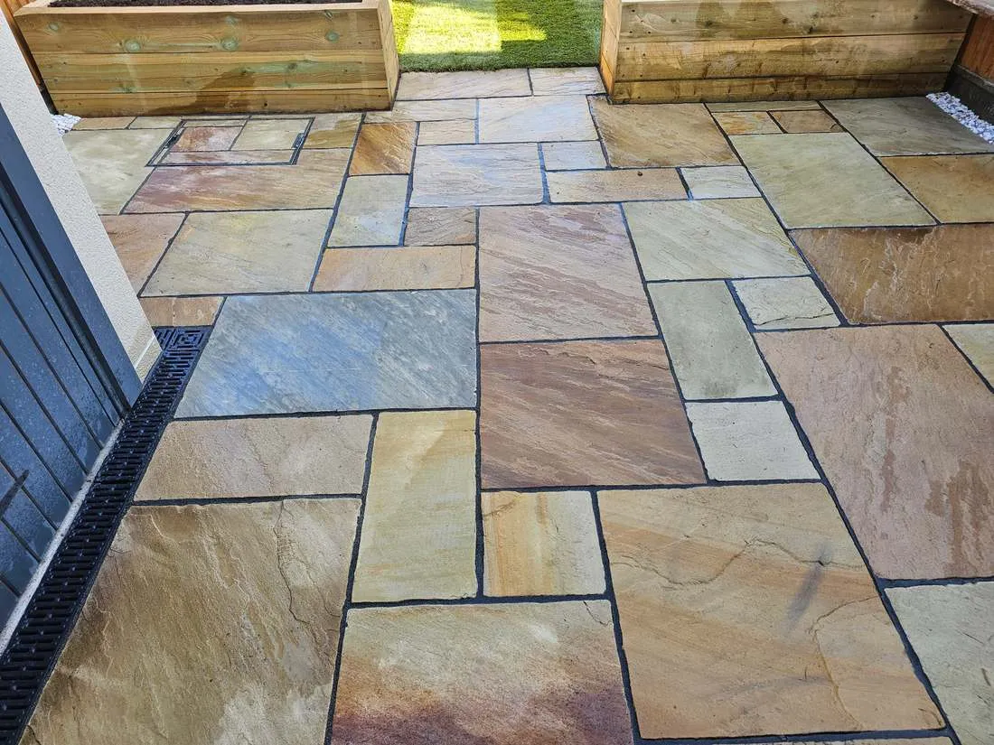 Indian sandstone patio with timber raised beds by DJG Groundworks