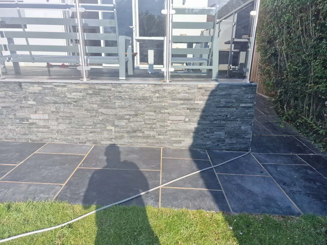 Stone-clad wall with a glass balustrade by DJG Groundworks